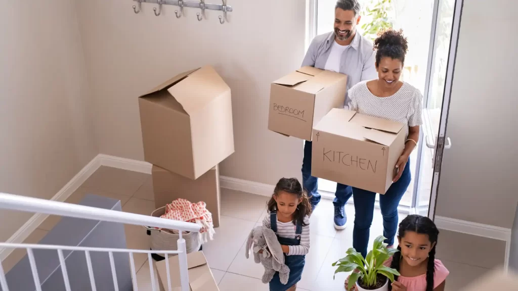 Smiling family unloading boxes while moving into their new home in Bentonville, Arkansas, ready to learn about local pest issues and prevention