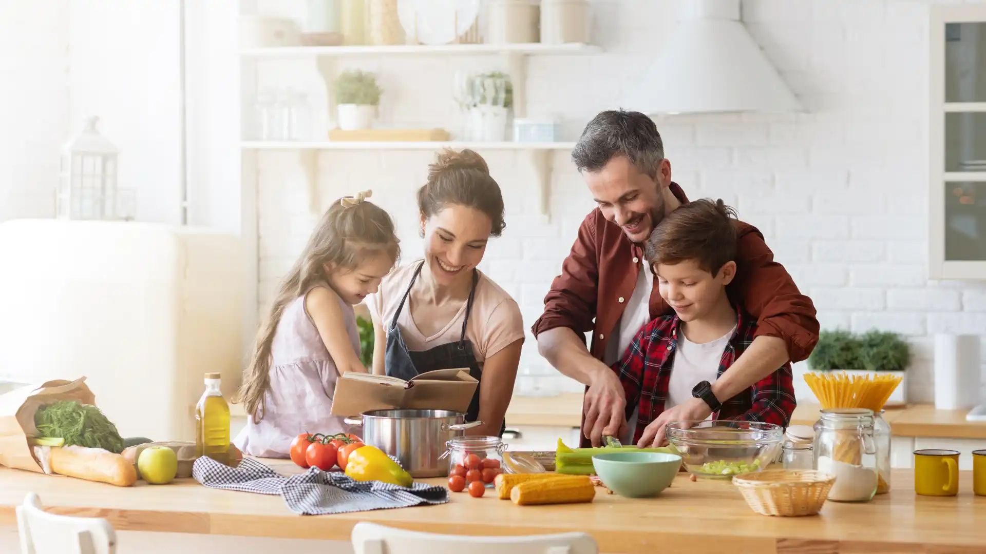 Smiling family cooking together in a bright, clean kitchen after safe pest control treatment in Northwest Arkansas